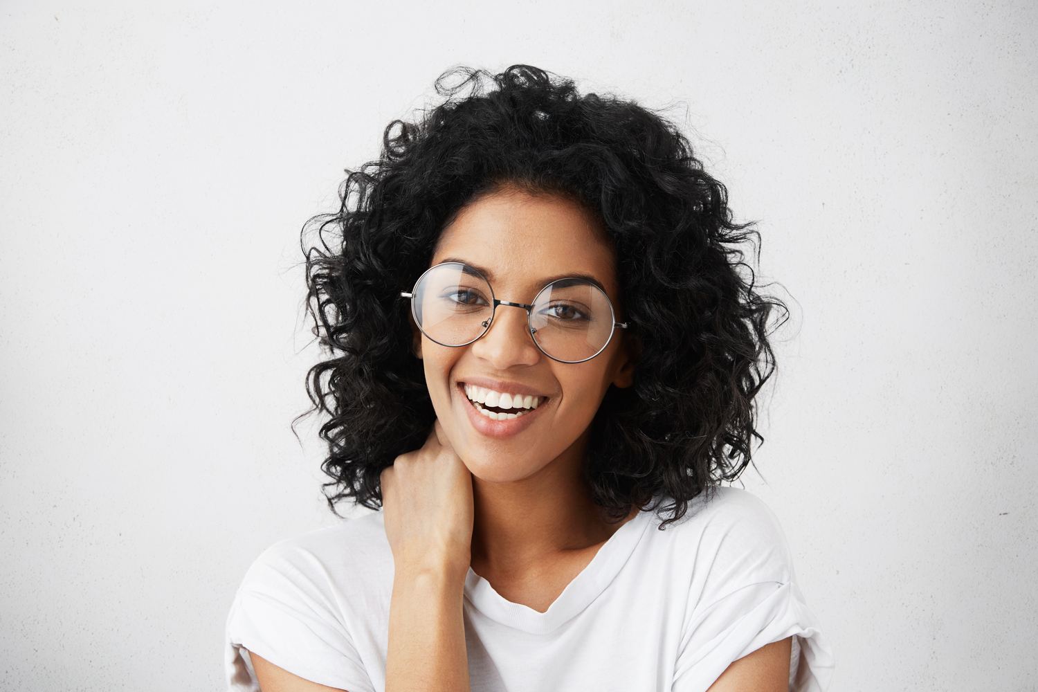 Mulher sorrindo com óculos de grau redondo