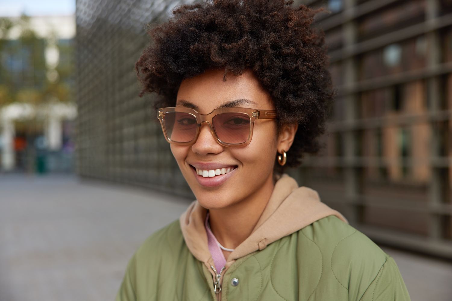 Mulher de cabelo cacheado com óculos de sol